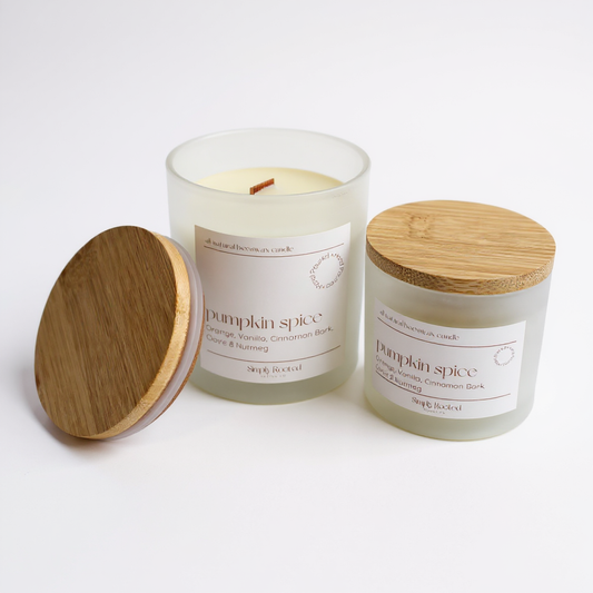 Two pumpkin spice candles with wooden lids on a white background